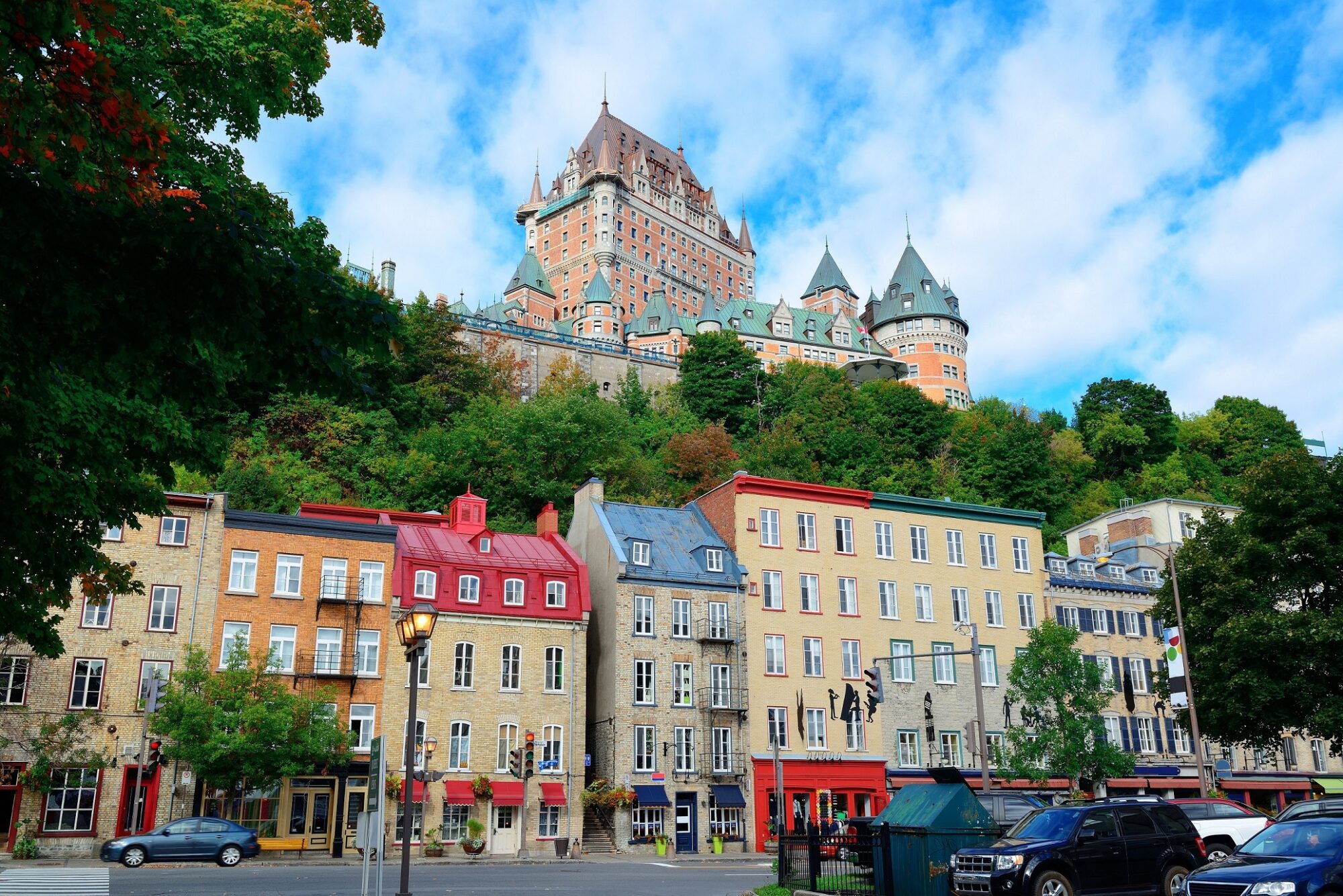 Chateau Frontenac in the day with colorful buildings on street in Quebec City